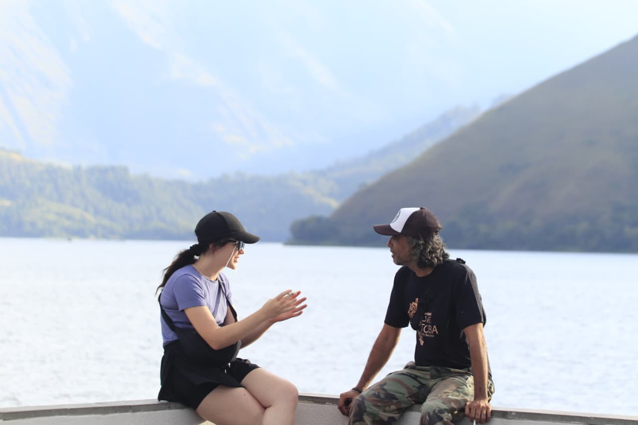 Ahmad speaking with an adult guest at Lake Toba