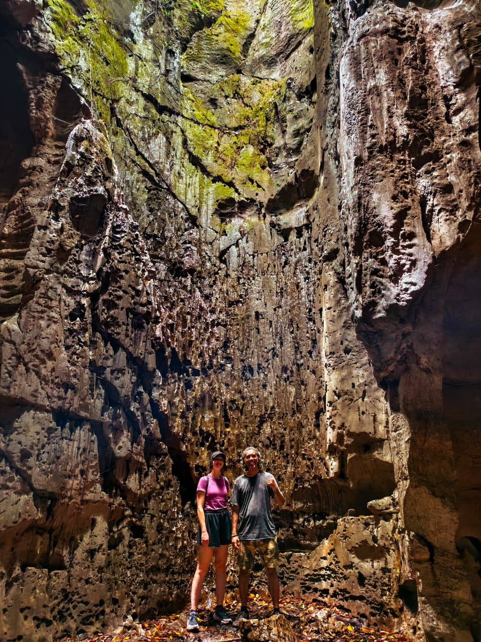 Adult guests and a local companion exploring a North Sumatra cave