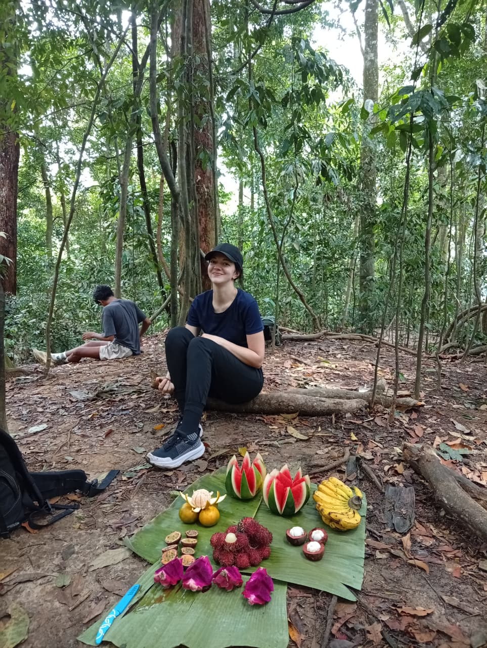 An adult guest enjoying tropical fruit during a Bukit Lawang trek