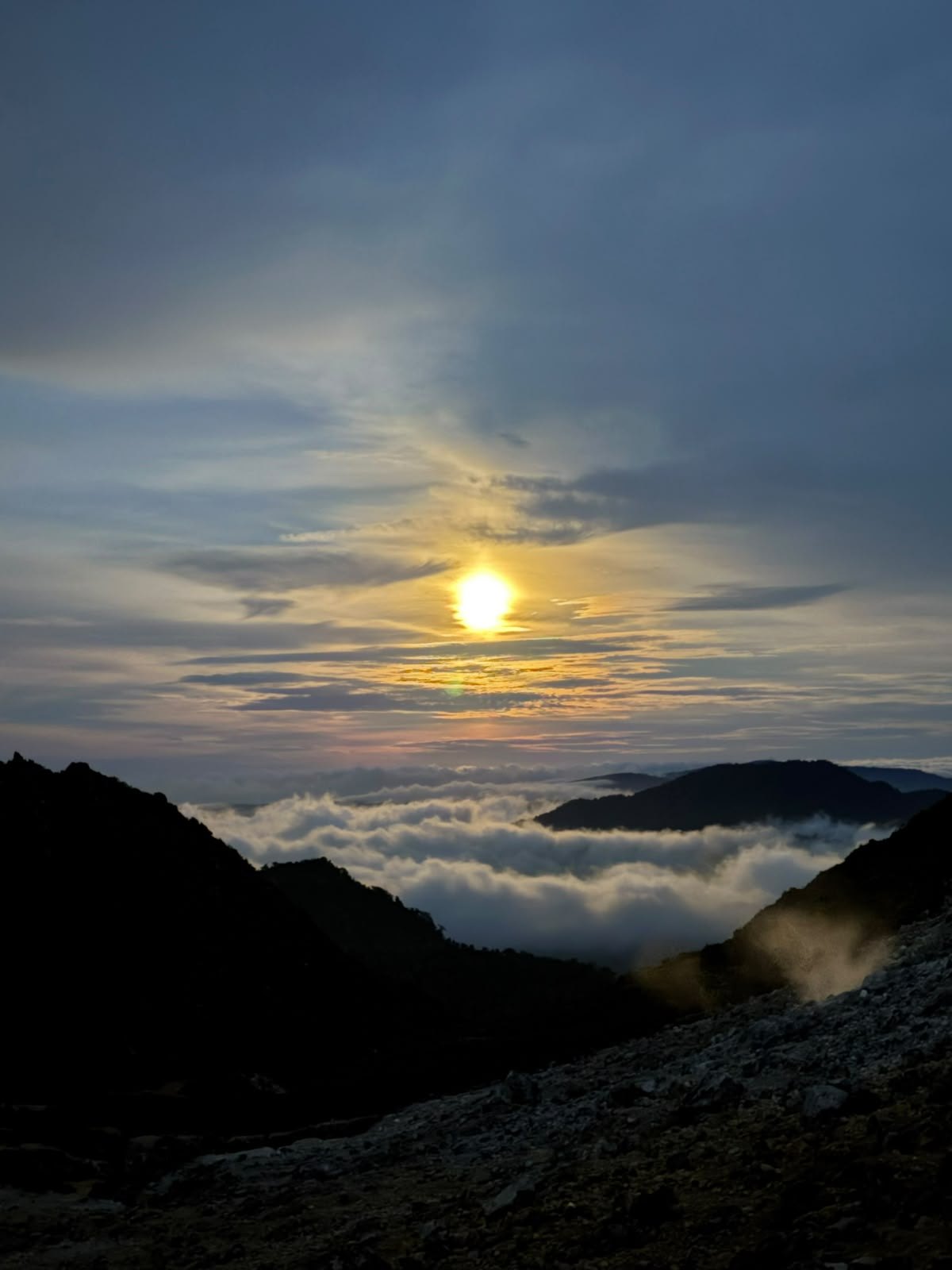 Morning light in the mountains. Golden sunlight above a sea of clouds and mountain silhouettes.